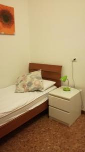 ヴェローナにあるLa Volieraのベッドルーム1室(ランプ付)、ナイトスタンドが備わります。