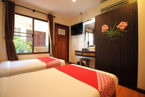 a hotel room with two beds and a window at OYO 482 Pannee Lodge Khaosan - SHA Plus in Bangkok