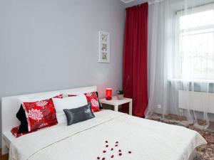 Schlafzimmer mit einem weißen Bett und roten Kissen in der Unterkunft Apartament Amaryllis in Krakau