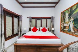 - une chambre avec un grand lit et des oreillers rouges dans l'établissement Lucas, à Bentota