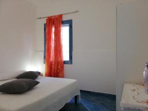 una camera da letto con letto e tenda arancione di Soleluna apartment a Donnalucata