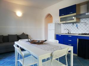 una cucina e una sala da pranzo con tavolo e sedie bianchi di Soleluna apartment a Donnalucata