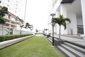a walkway with palm trees in a building at Pinnacle Tower Homestay by Home Cube in Johor Bahru