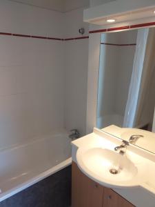 a bathroom with a sink and a bath tub at Appartement F2 au domaine des 100 lacs - piscine - sauna - hammam in Cauterets