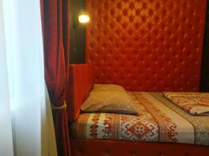 a bed with a red headboard and a pillow at Arabica in Yoshkar-Ola