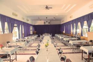 a room with rows of tables and chairs at Berlian Abadi Hotel by Sinergi in Banyuwangi