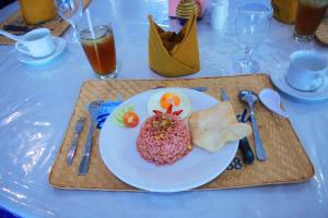 a plate of food on a table with a plate of food at Berlian Abadi Hotel by Sinergi in Banyuwangi