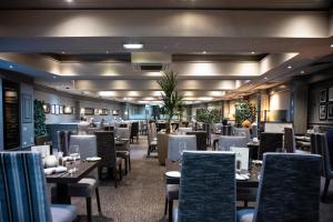 a dining room filled with tables and chairs at Normandy Hotel (Near Glasgow Airport) in Paisley