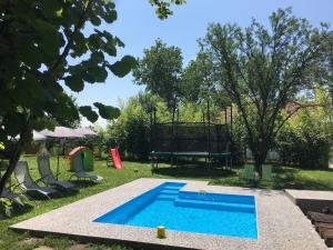 a swimming pool in a yard with a table and chairs at Dve kuce pored jezera in Palić