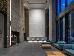 a lobby of a building with couches and tables at Keio Prelia Hotel Sapporo in Sapporo