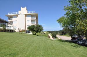 a large building with a grassy hill in front of it at Alma Marina in Valeria del Mar