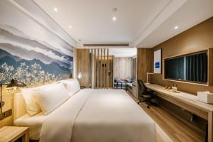 a hotel room with a large bed and a desk at Atour Hotel Changsha Lugu Branch in Changsha