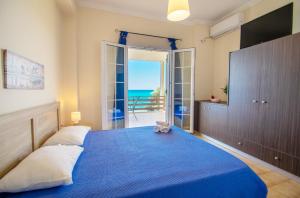 a bedroom with a blue bed with a view of the ocean at Paradiso Del Mare On the Beach in Zakynthos Town