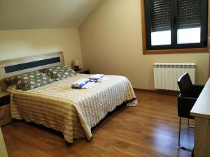 1 dormitorio con 1 cama, 1 silla y 1 ventana en Panxón, en Nigrán