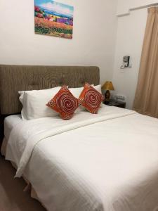 uma grande cama branca com duas almofadas em Kerteh Apartment em Kertih
