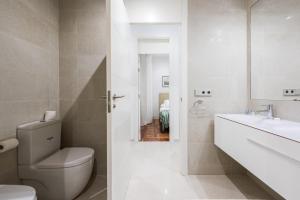 biała łazienka z toaletą i umywalką w obiekcie PUERTA DEL SOL CITY CENTER III w Madrycie