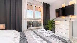 een slaapkamer met een bed met handdoeken erop bij Maya's Flats & Resorts 26 - Panorama View in Gdańsk