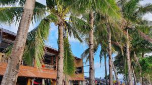 a group of palm trees in front of a building at Bamboo Beach Resort & Restaurant in Boracay