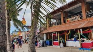 a palm tree in front of a store on the beach at Bamboo Beach Resort & Restaurant in Boracay