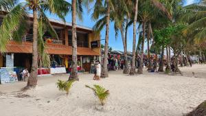 einen Strand mit Palmen vor einem Gebäude in der Unterkunft Bamboo Beach Resort & Restaurant in Boracay