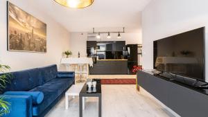 uma sala de estar com um sofá azul e uma cozinha em Maya's Flats & Resorts 26 - Panorama View em Gdansk