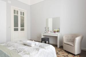 a bedroom with a bed and a chair and a desk at Gramignani House Catania in Catania