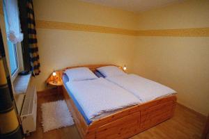 - une chambre avec un lit en bois et 2 oreillers dans l'établissement Ruegen_Fewo 35, à Putbus