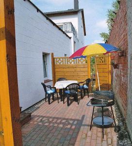 une terrasse avec une table, des chaises et un parasol dans l'établissement Ruegen_Fewo 35, à Putbus