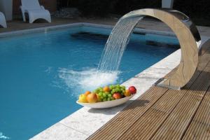 a bowl of fruit sitting next to a swimming pool at Hotel Bellevue in Bad Ragaz