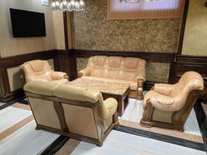 uma sala de espera com sofás e uma mesa e cadeiras em Хотел ЦЕНТРАЛ em Stara Zagora