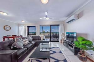 a living room with a couch and a table at Ambience of Airlie - Airlie Beach in Airlie Beach