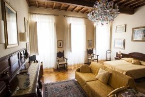 ein Wohnzimmer mit einem Sofa, einem Bett und einem Kronleuchter in der Unterkunft Soggiorno Antica Torre in Florenz