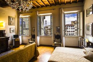 a bedroom with a bed and two large windows at Soggiorno Antica Torre in Florence