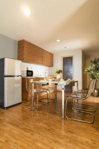 a kitchen with a refrigerator and a table and chairs at Ploen Place Residence in Pattaya Central