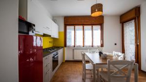 uma cozinha com um frigorífico vermelho e uma mesa com cadeiras em Italianway - Susans 8 em Udine