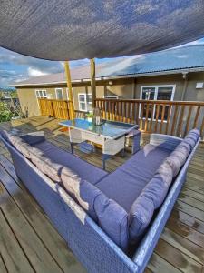 un sofá grande en una terraza con mesa en Breathtaking sea view house叹为观止全海景别墅 en Oamaru
