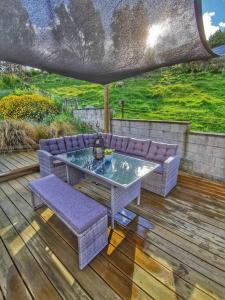una mesa y sillas en una terraza de madera en Breathtaking sea view house叹为观止全海景别墅 en Oamaru