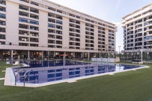 a large building with a swimming pool in front of it at Marin Beach Apartments Patacona in Valencia