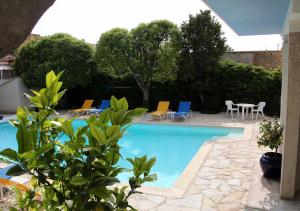 una piscina con sillas y una mesa en Paradix holiday apartment - gîte 2, 2 pers, en Nissan-lez-Enserune