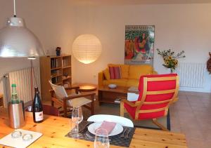 sala de estar con mesa y sofá amarillo en Paradix holiday apartment - gîte 2, 2 pers, en Nissan-lez-Enserune