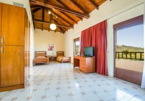 a living room with a large window and a television at ERIA RESORT for people with special abilities in Maleme