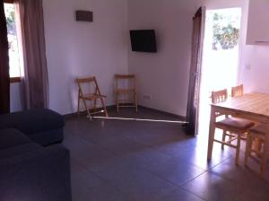 salon z kanapą, stołem i krzesłami w obiekcie Domaine Casa Andria w mieście Barbaggio