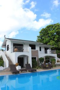 una casa con piscina frente a ella en Sun Properties and Resort Hotel en Beau Vallon