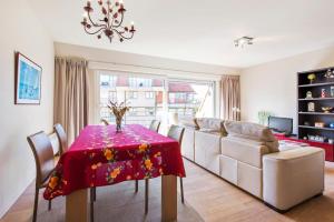 un soggiorno con tavolo e divano di Bright apartment with 2 terraces in De Panne a De Panne