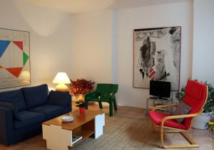 sala de estar con sofá azul y sillas en Paradix holiday apartment - gîte 3, 2 pers, en Nissan-lez-Enserune