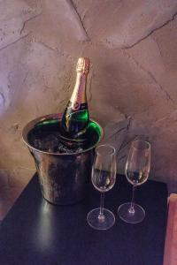 una bottiglia di champagne in un secchio con due bicchieri di vino di Sauna Central a Praga
