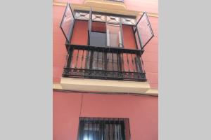 a balcony on the side of a red building at Cheap & Chic in the center of Sevilla in Seville