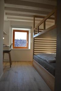 ein Schlafzimmer mit einem Etagenbett und einem Fenster in der Unterkunft Dimora Sannicolò - Talento in Rovereto