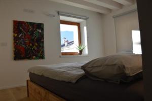 um quarto com uma cama e um quadro na parede em Dimora Sannicolò - Talento em Rovereto