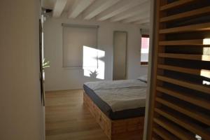 Schlafzimmer mit einem Bett und einem Fenster in der Unterkunft Dimora Sannicolò - Talento in Rovereto